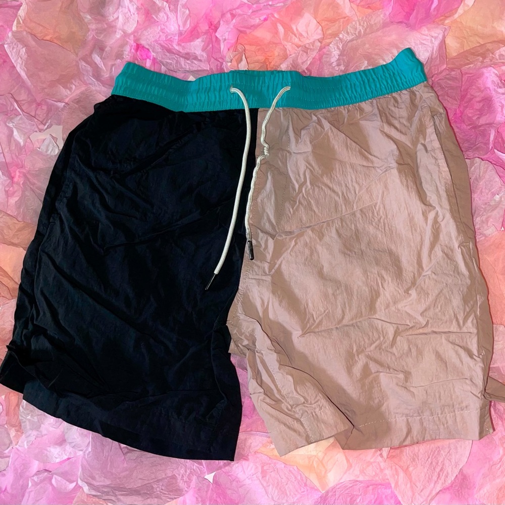 Pink, black, and bright blue colorblock swim shorts. Cropped